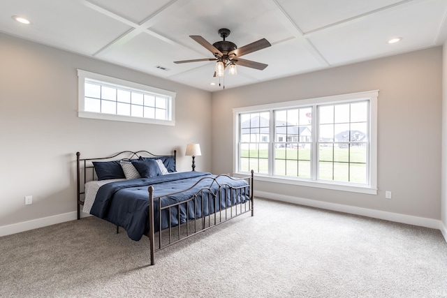 carpeted bedroom featuring coffered ceiling, multiple windows, and ceiling fan