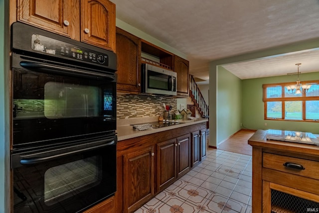 kitchen featuring decorative light fixtures, a notable chandelier, decorative backsplash, light tile patterned floors, and black double oven