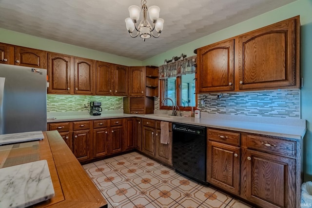 kitchen with black dishwasher, a chandelier, stainless steel refrigerator, pendant lighting, and sink