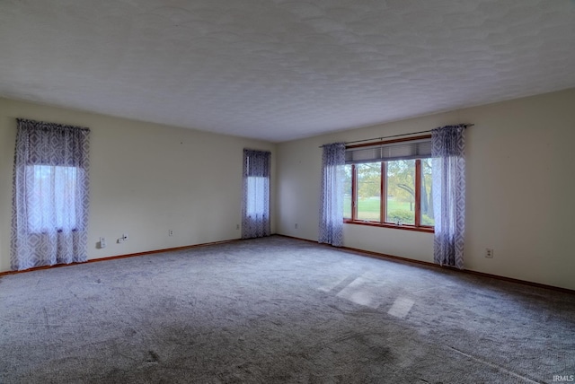 carpeted empty room featuring a textured ceiling