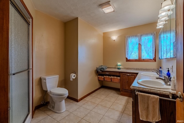 bathroom with vanity, a shower with shower door, toilet, and tile patterned floors