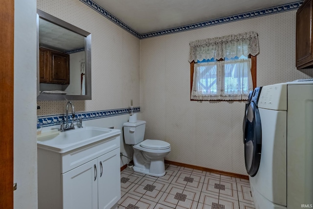 bathroom with vanity, toilet, and washer / clothes dryer