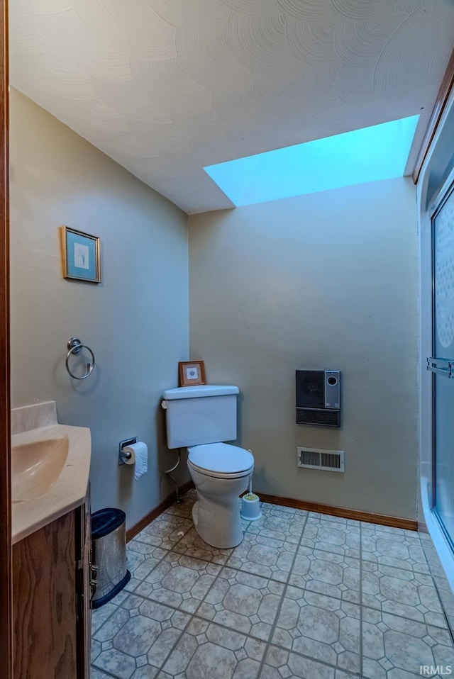 bathroom featuring a shower with door, vanity, toilet, and plenty of natural light