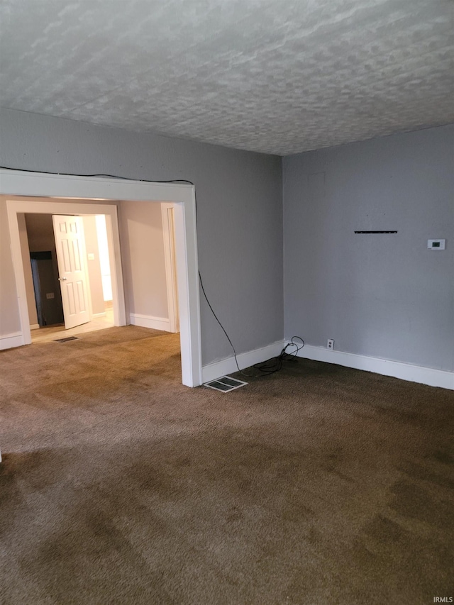 unfurnished room featuring carpet and a textured ceiling