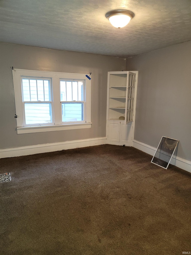 empty room featuring a textured ceiling and carpet floors