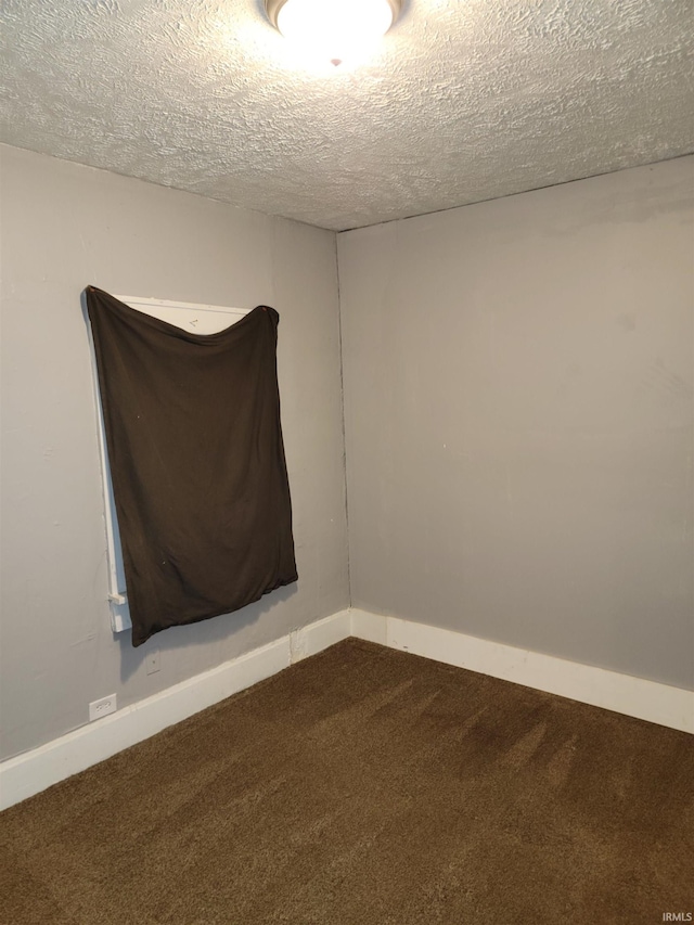 empty room featuring a textured ceiling and carpet floors