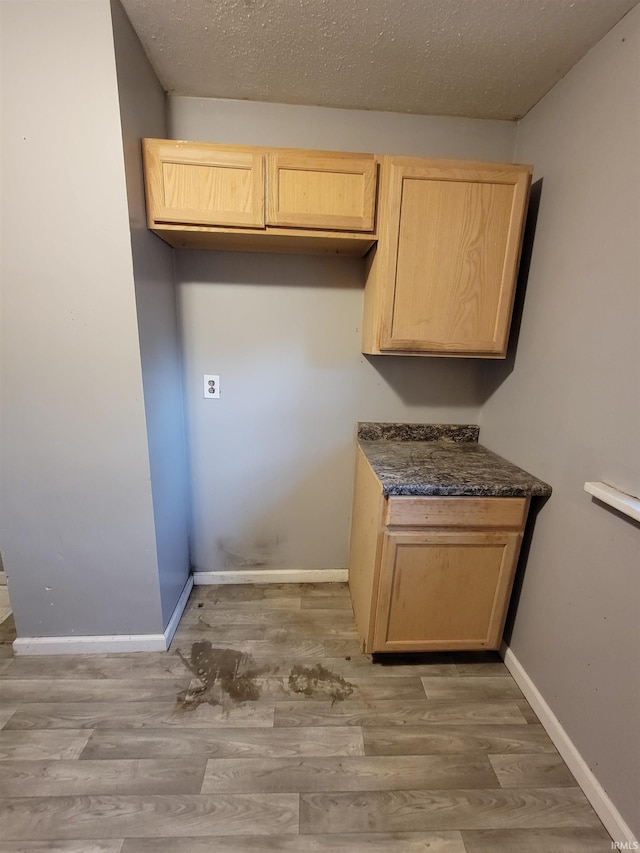 laundry room with a textured ceiling and hardwood / wood-style floors