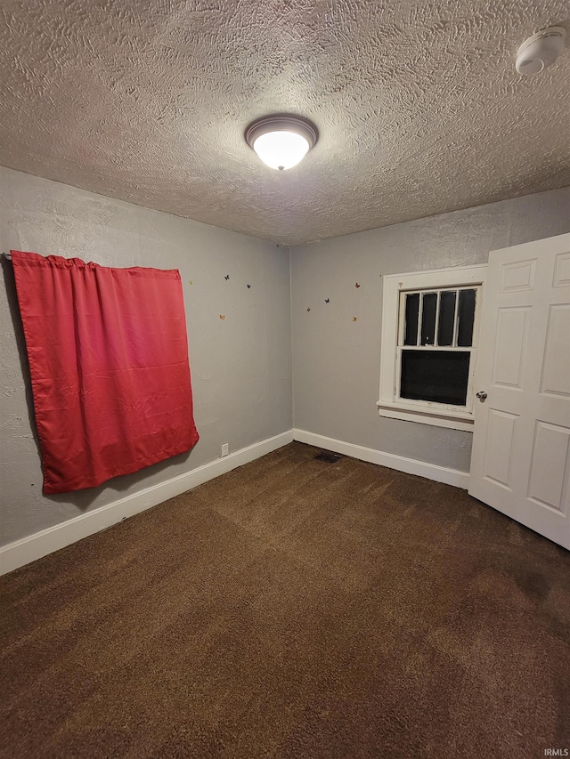 empty room featuring a textured ceiling and carpet floors