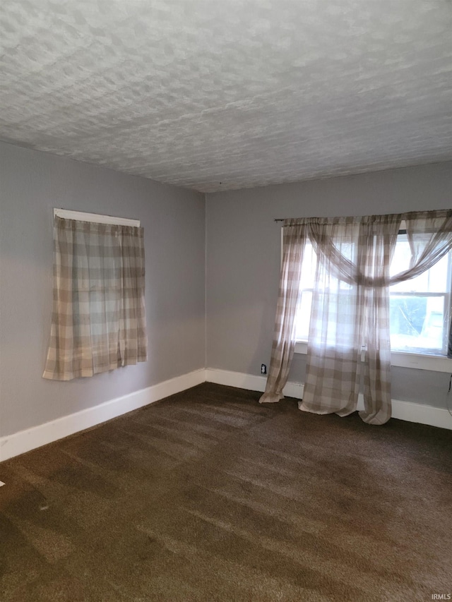 carpeted empty room featuring a textured ceiling