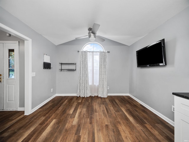 unfurnished living room with lofted ceiling, a wealth of natural light, and dark hardwood / wood-style flooring