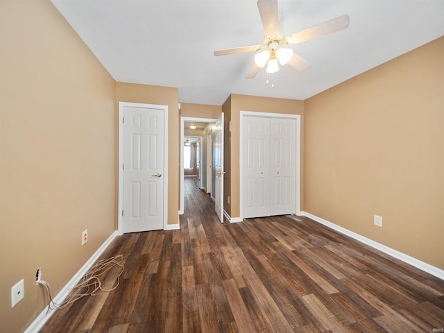 unfurnished bedroom with a closet, dark hardwood / wood-style floors, and ceiling fan