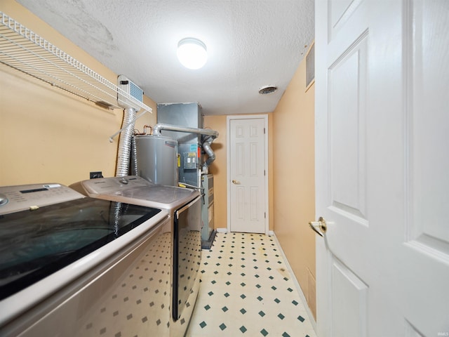 laundry area with washing machine and dryer, gas water heater, and a textured ceiling