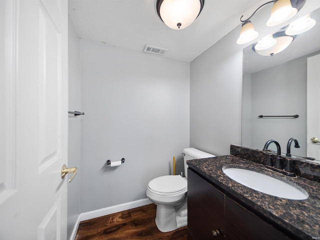 bathroom featuring toilet, vanity, and wood-type flooring