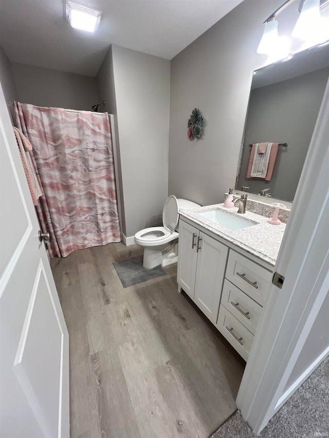 bathroom with vanity, toilet, wood-type flooring, and curtained shower