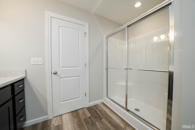 bathroom with a shower with door, vanity, and hardwood / wood-style floors