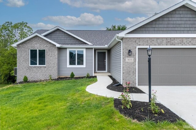 303 Renee Way, Albion, IN 46701 - ranch-style home with an attached garage, brick siding, driveway, and a front yard