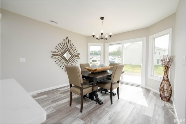 dining area featuring a notable chandelier and light hardwood / wood-style flooring