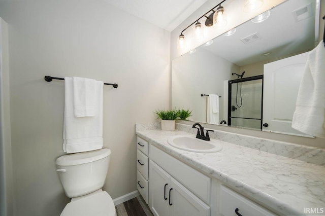 bathroom with a shower with door, toilet, hardwood / wood-style flooring, and vanity