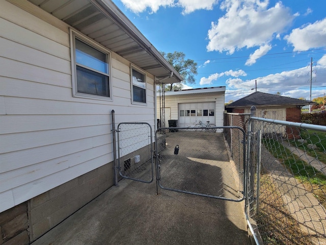 view of patio with a garage and an outbuilding