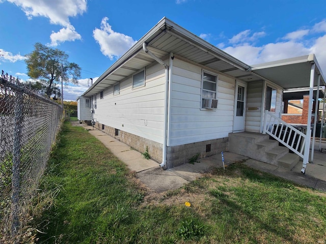 view of home's exterior featuring cooling unit and a lawn