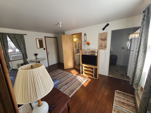 bedroom with dark wood-type flooring, ensuite bathroom, and white refrigerator