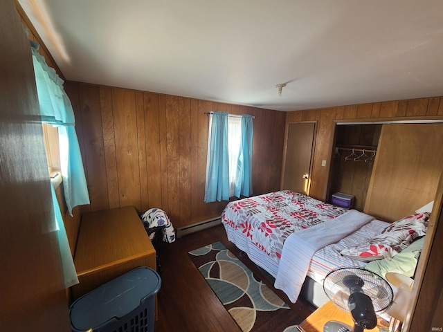 bedroom featuring a closet, a baseboard heating unit, wooden walls, and dark hardwood / wood-style floors