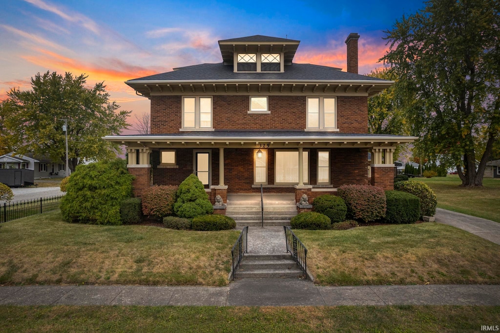 view of front of house with a porch and a lawn