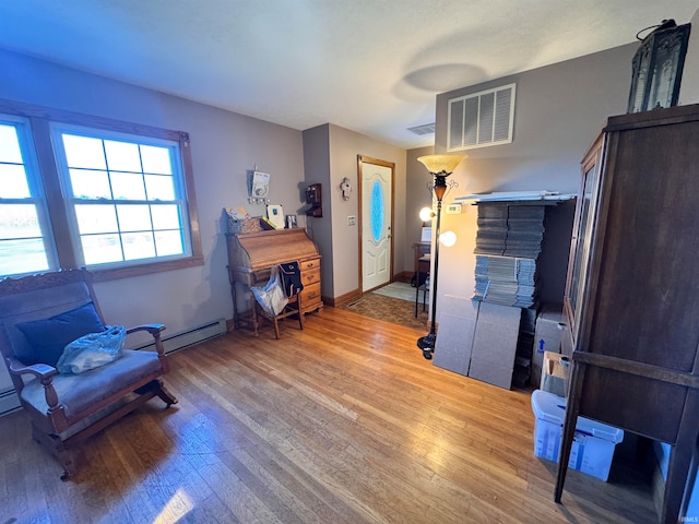 interior space featuring a baseboard heating unit and hardwood / wood-style floors