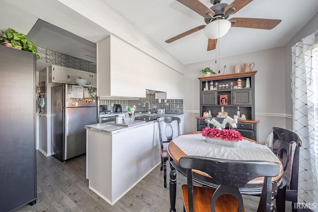 4501 N Wheeling Ave Unit 5-1A, Muncie, IN 47304 - kitchen with freestanding refrigerator, a peninsula, wood finished floors, and ceiling fan