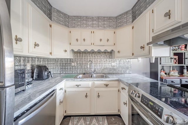 kitchen with appliances with stainless steel finishes, sink, and white cabinets