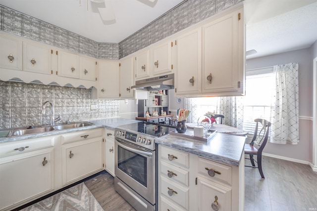 kitchen featuring kitchen peninsula, sink, hardwood / wood-style floors, white cabinets, and electric stove