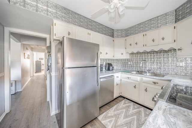 kitchen featuring sink, white cabinetry, stainless steel appliances, and light wood-type flooring