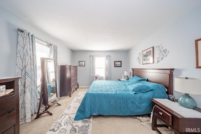 bedroom with light carpet and a textured ceiling