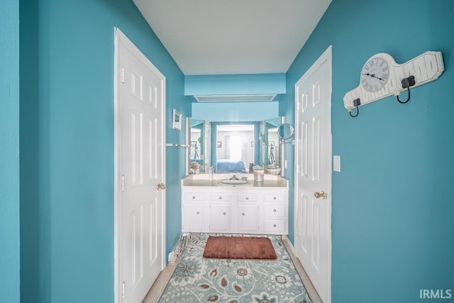 corridor featuring sink and light tile patterned floors