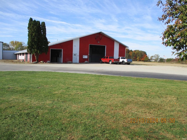 view of outdoor structure with a garage and a lawn