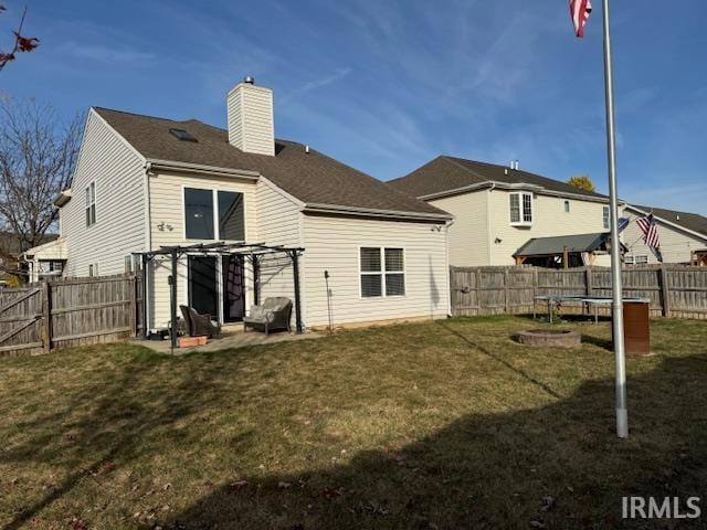 rear view of property featuring a yard, a patio, and a pergola