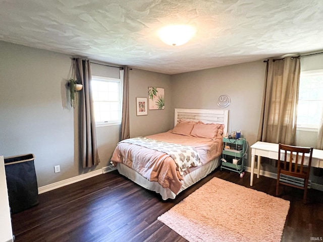 bedroom with dark hardwood / wood-style flooring and a textured ceiling