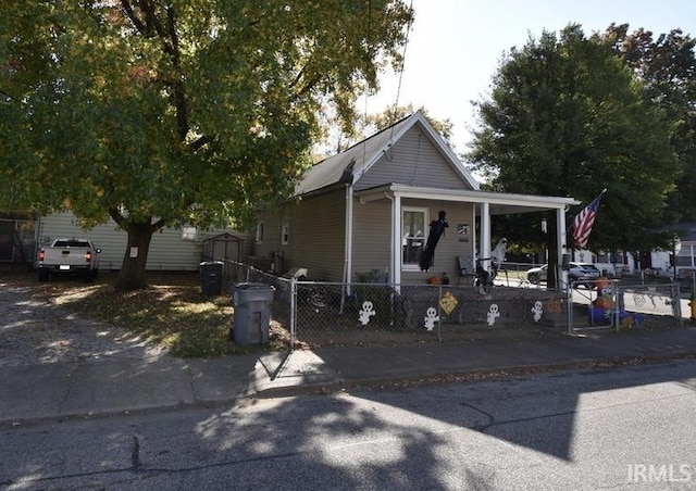 524 W Louisiana Ave, Evansville, IN 47710 - view of front of house featuring a porch, a storage shed, and an outbuilding