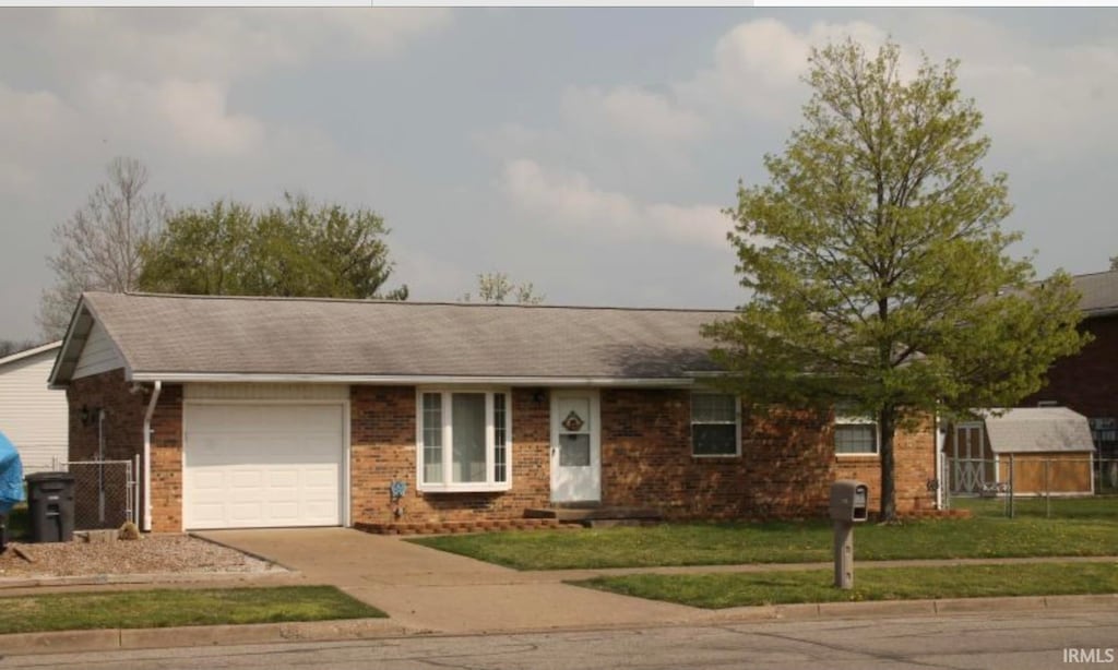 ranch-style house featuring a garage and a front lawn