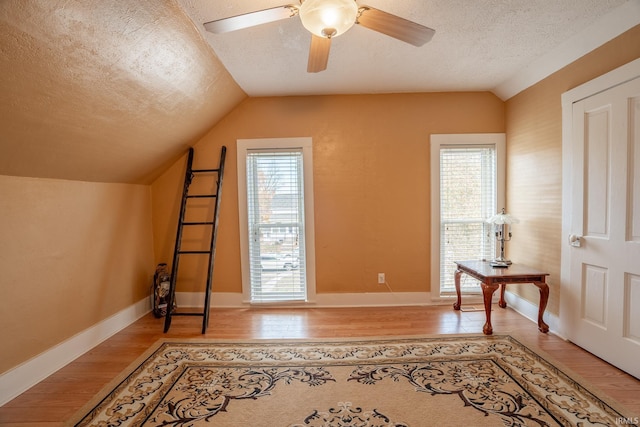 bonus room featuring ceiling fan, a textured ceiling, lofted ceiling, and hardwood / wood-style floors