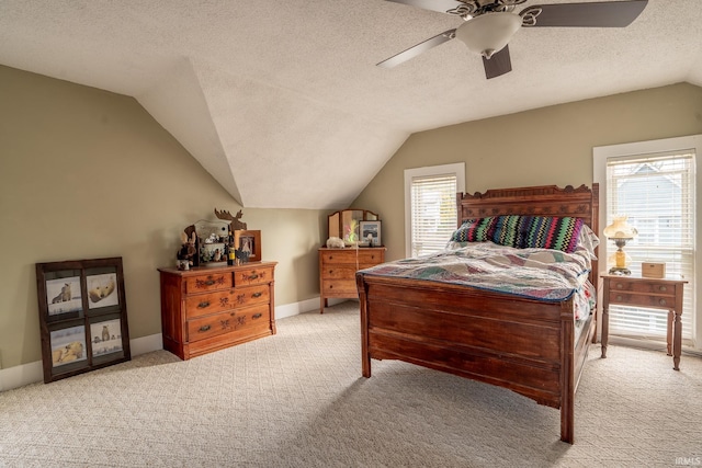 bedroom with ceiling fan, a textured ceiling, lofted ceiling, and light colored carpet