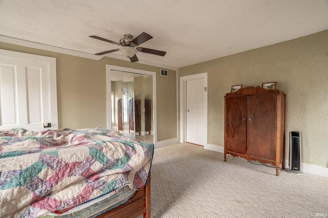 carpeted bedroom featuring a closet, ceiling fan, and a textured ceiling