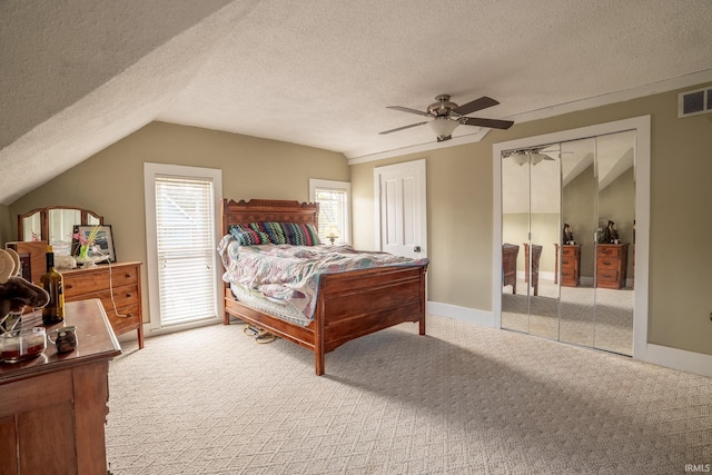 bedroom with lofted ceiling, a textured ceiling, light colored carpet, and ceiling fan