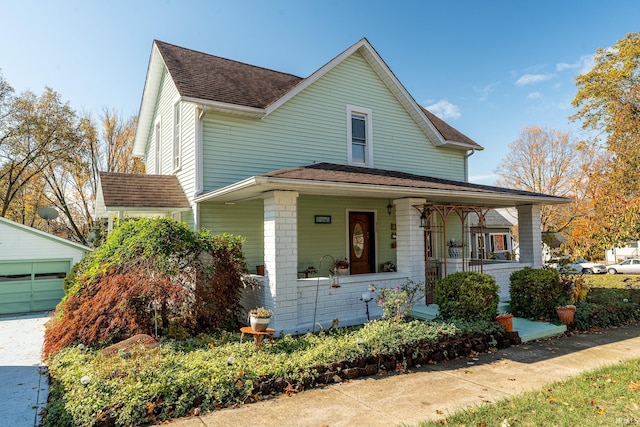 view of front of property with an outdoor structure, covered porch, and a garage