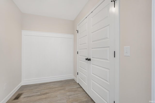 interior space with a barn door and light hardwood / wood-style flooring