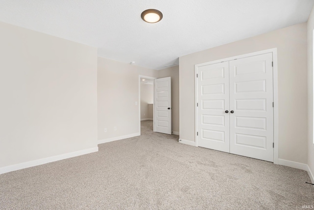 unfurnished bedroom featuring a closet and light colored carpet