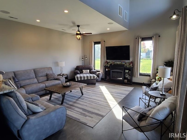 living room featuring ceiling fan and concrete flooring