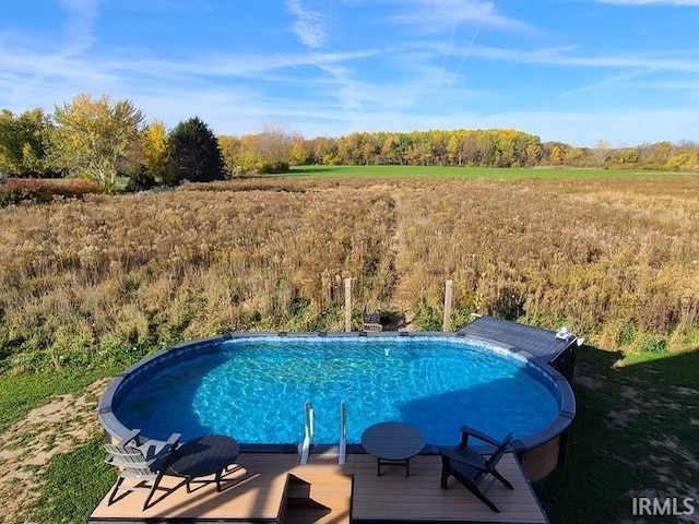 view of swimming pool featuring a rural view