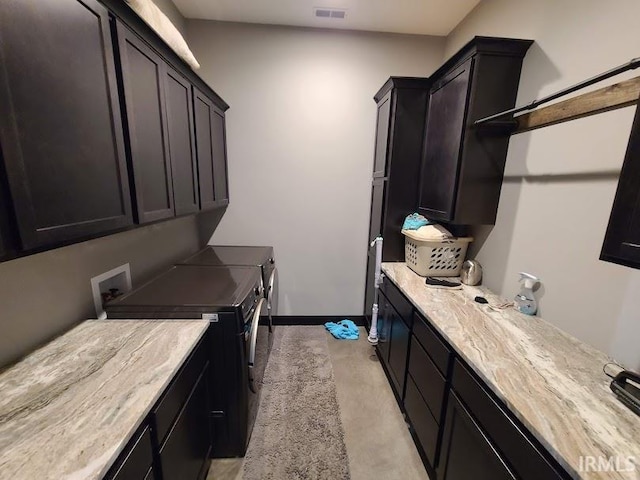 laundry area with washer and clothes dryer, light colored carpet, and cabinets