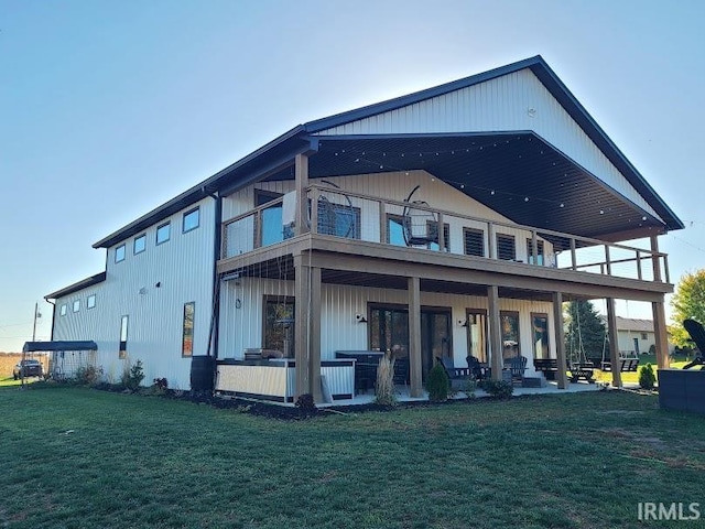 back of property with a patio area, a lawn, and a balcony